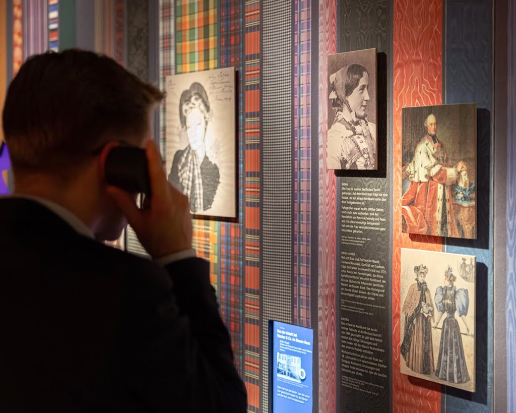 Mann hört an einer Hörstation in der Seidenband-Ausstellung im Museum Basel-Landschaft